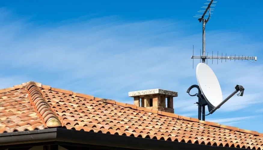 Technicien antenniste réglant une antenne TV